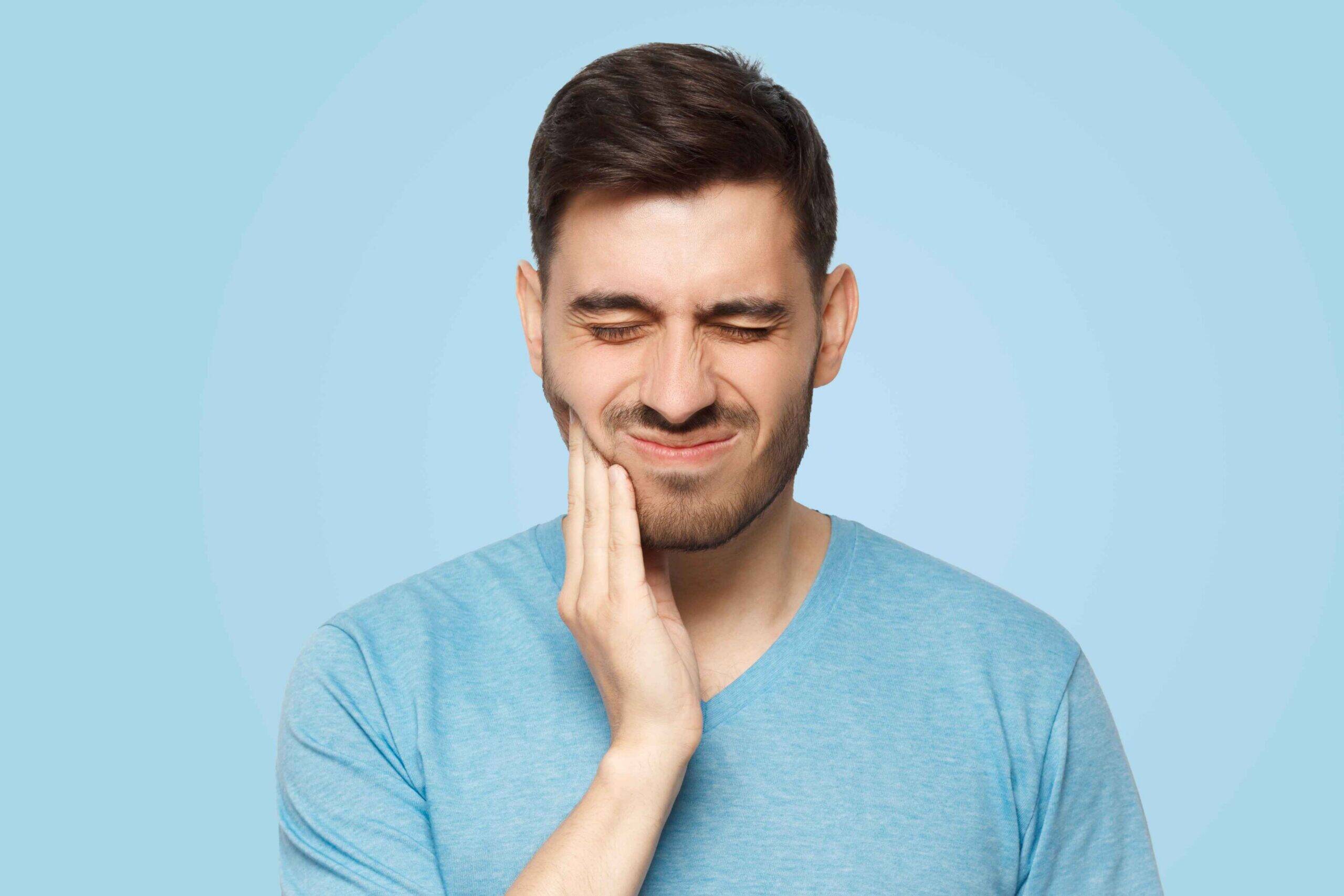 Man holding his jaw due to severe tooth pain.